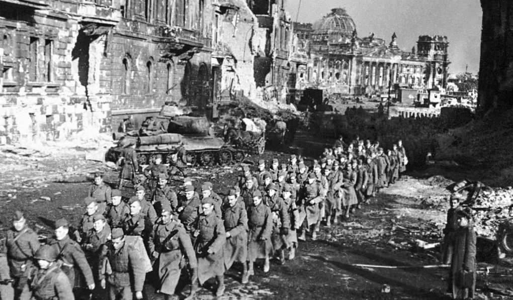 Советские солдаты уходят от захваченного в бою Рейхстага