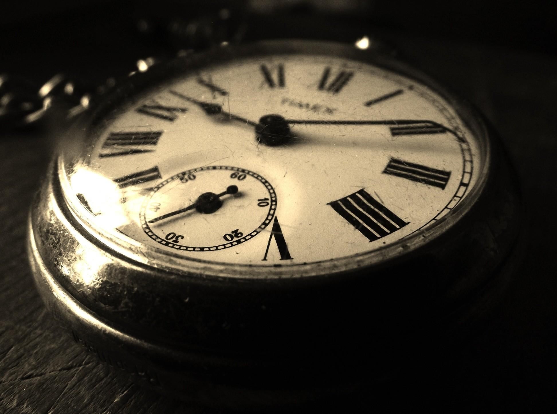 Часы лежат на столе. Старинные часы. Винтажные часы. Антикварные часы. Красивые старинные часы.