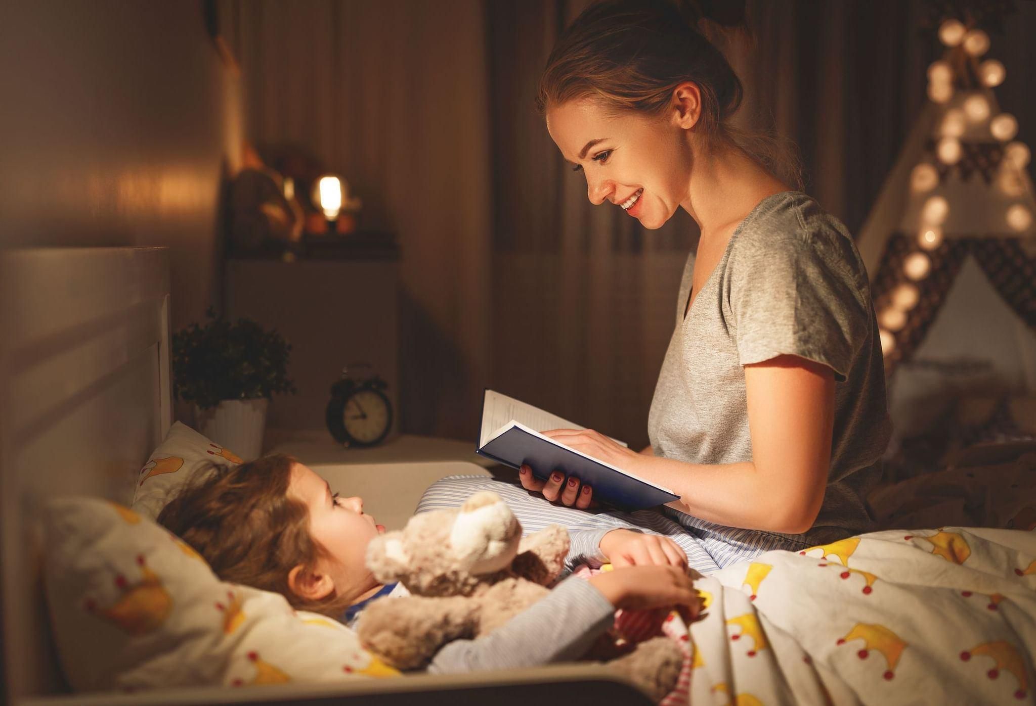 Мама читает книгу ребенку