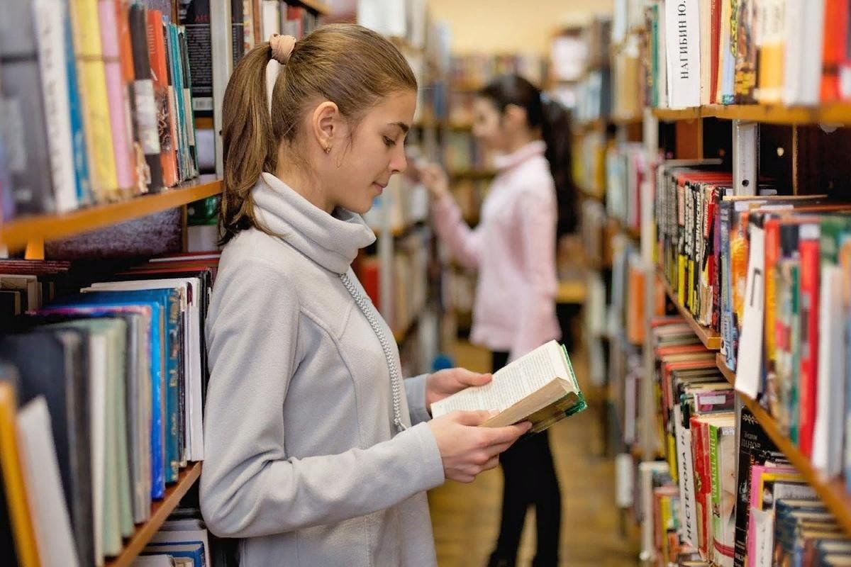 Книги среди молодежи. Чтение в библиотеке. Молодежь и книга. Читает в библиотеке. Молодежь в библиотеке.