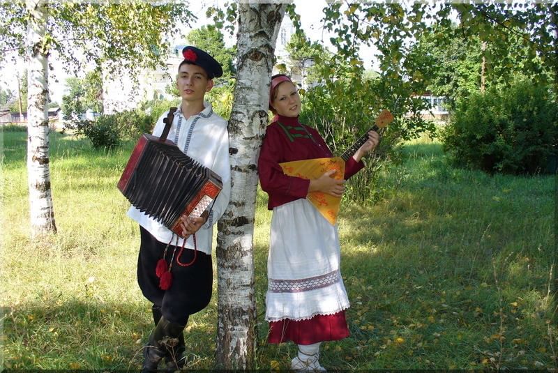 Песня русский танцует и поет. Парень с гармошкой и девушка. Береза и русские народные костюмы. Гармонисты в фольклорных костюмах. Праздник русской березы в России.