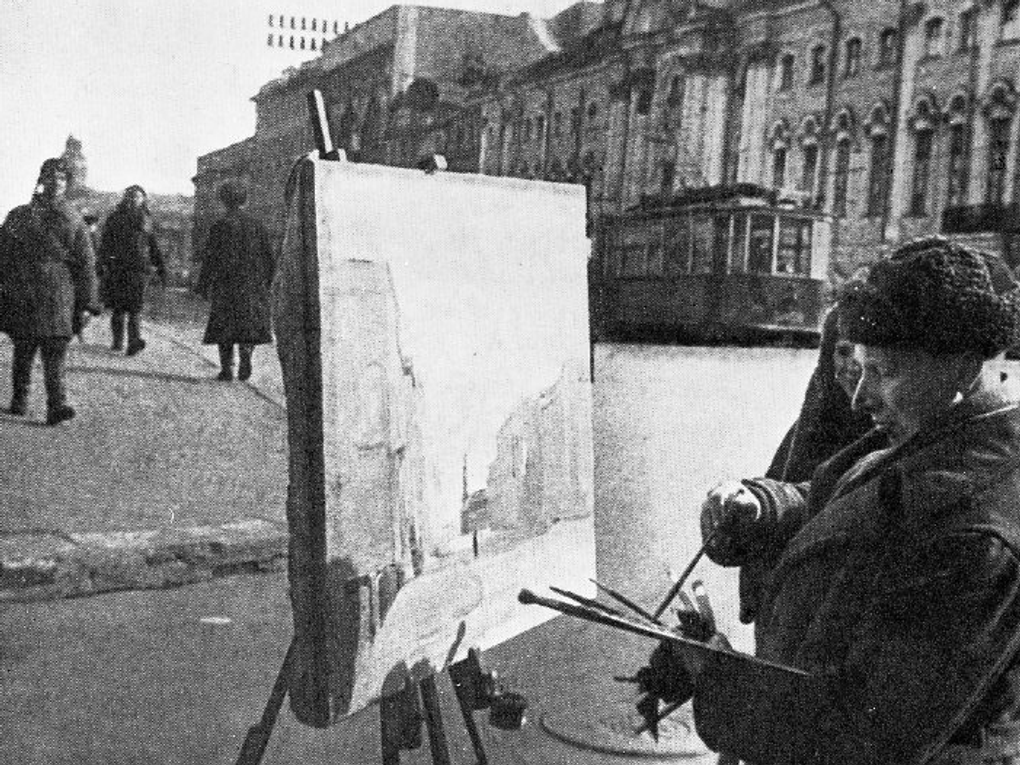 Художник Вячеслав Пакулин делает зарисовки на Невском проспекте. Ленинград, 1943 год. Фотография: <a href="https://artsacademy.ru/additionally/patrioticheskoe-vospitanie/akademiya-khudozhestv-v-gody-vov/" target="_blank" rel="noopener">artsacademy.ru</a>