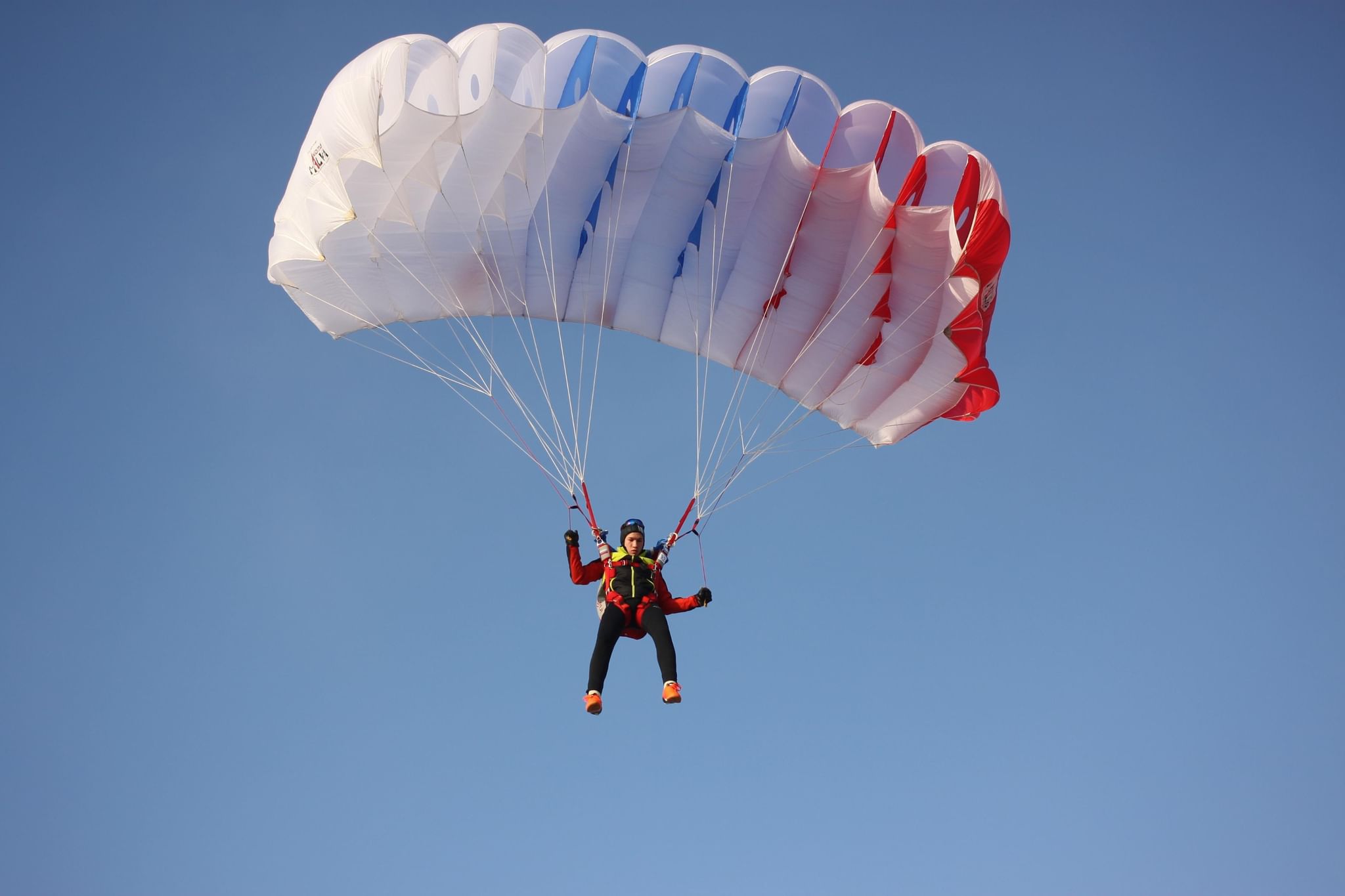 Спортсмен спускаясь на парашюте. Парашют. Парашютный спорт. Полет на парашюте. Человек с парашютом.