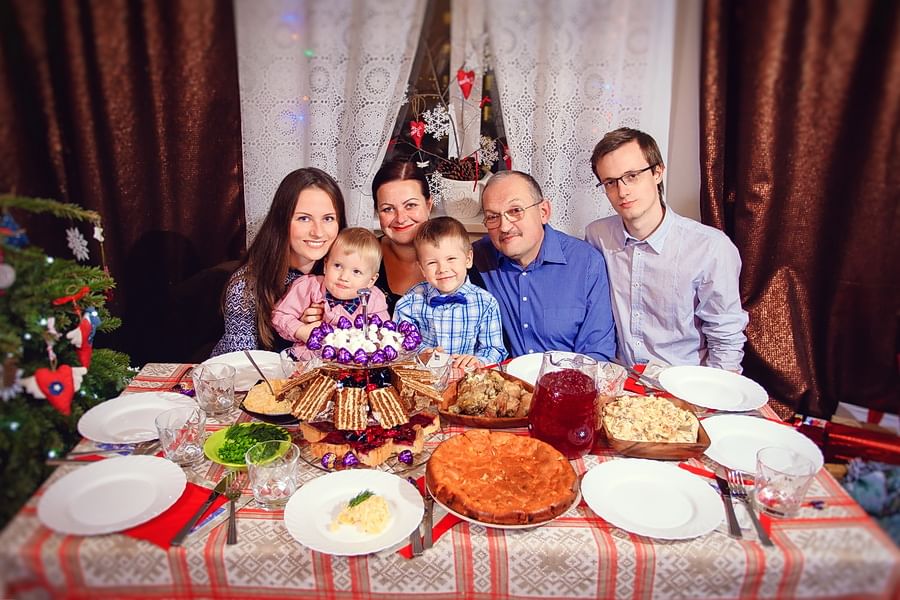 Отмечаем в кругу семьи. Новогодний стол семья. Семья за новогодним столом. Семейный новогодний ужин. Празднование дня рождения в семье.