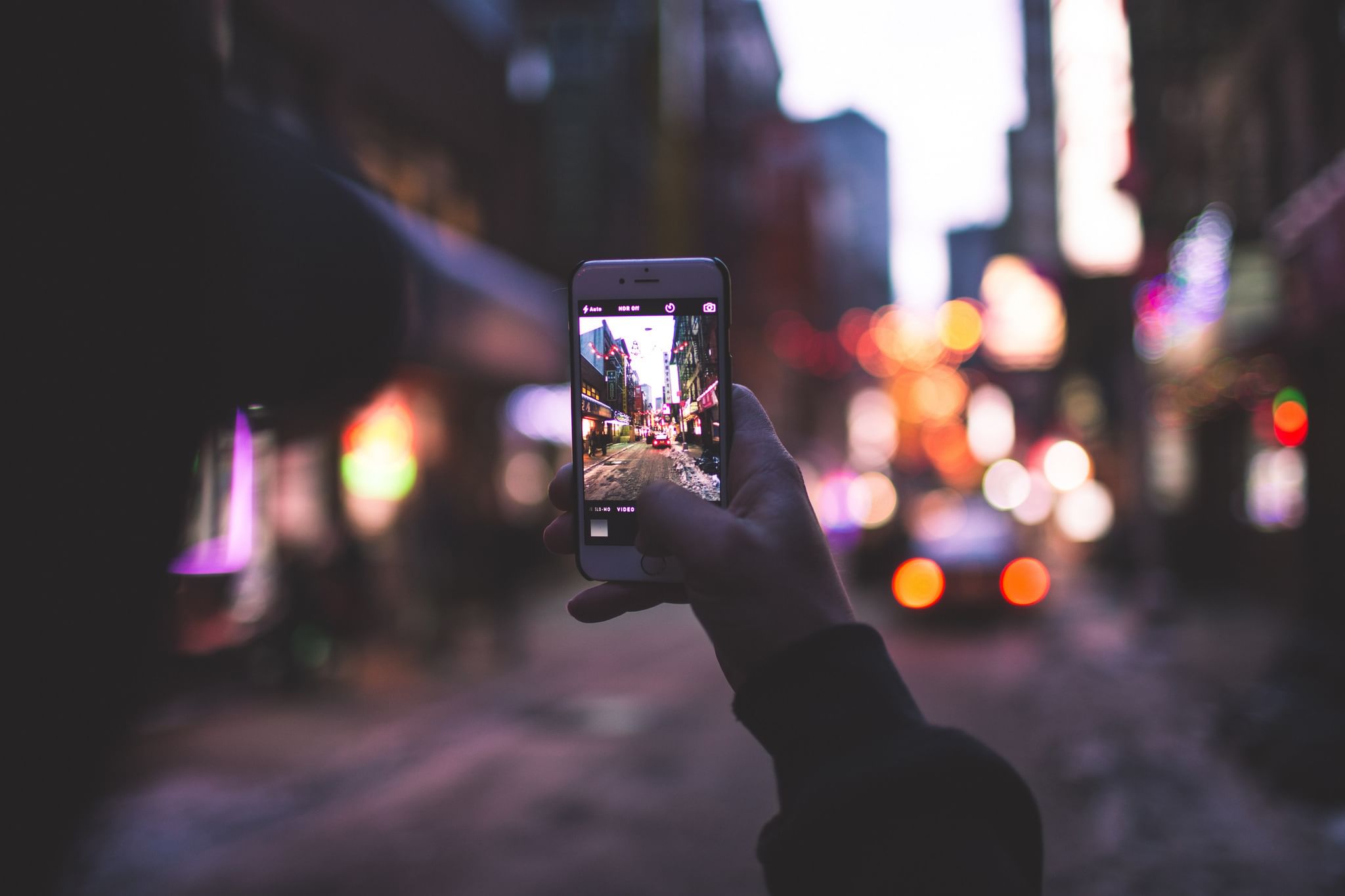 Ночное фото на телефоне. Смартфон в руке на улице. Ночная съемка на телефон. Фотоаппарат и городские улицы. Девушка фотографирует город на телефон.