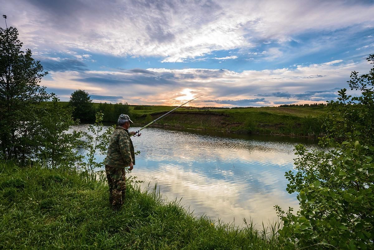 Рыбак на берегу водоема. Рыбалка. Рыбалка на реке. Рыбалка на речке. Рыбак на реке.