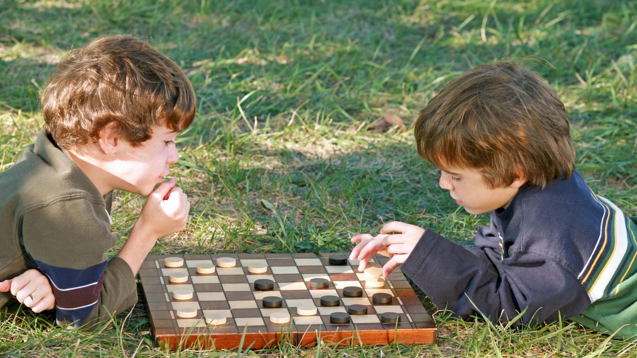 Игра игроками с шашкой. Дети играющие в шашки. Шашки для детей. Дети играют в настольные игры.